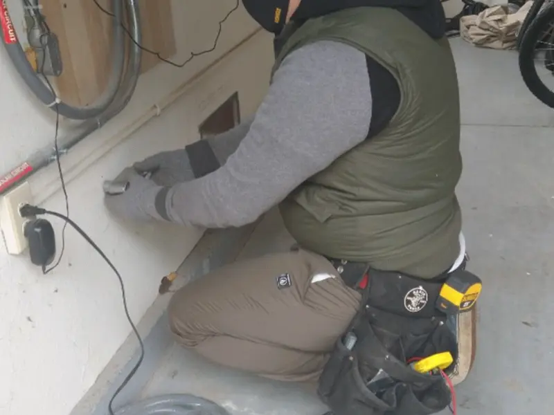 Electrician performing outlet wiring in a Boone garage